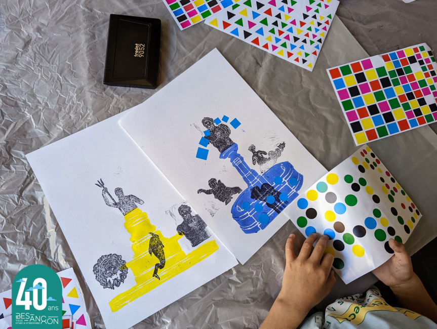 photographie d'un enfant où l'on voit ses mains en train de coller des gommettes sur une peinture de fontaine